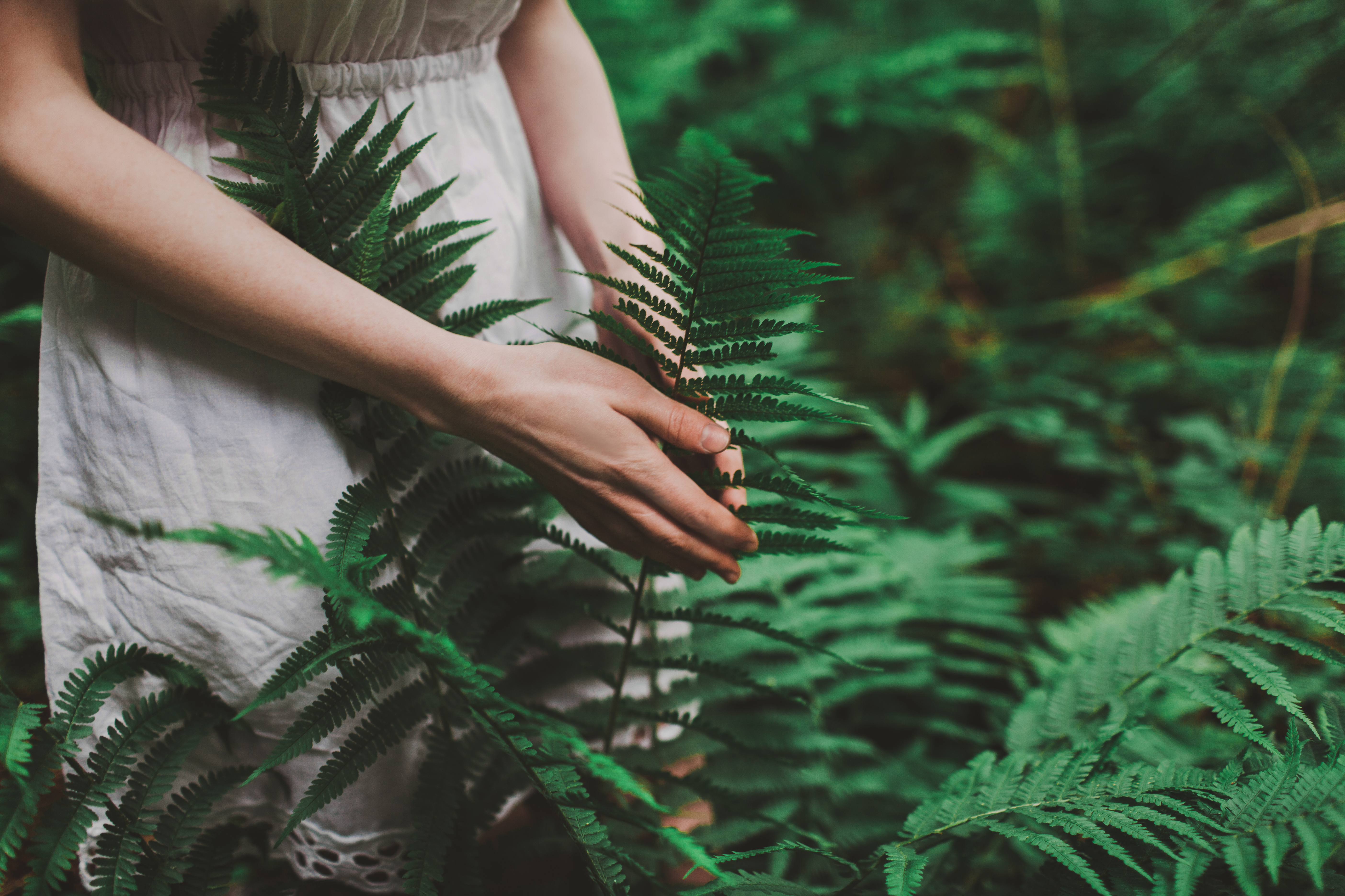 Woman in white dress walking in the forest